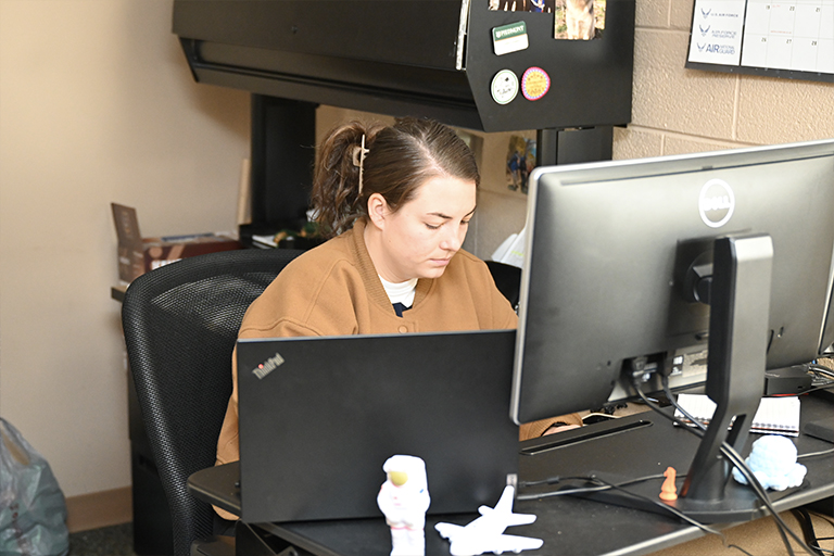 PCC employee working at their desk.