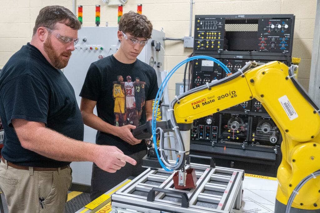 Photo of instructor and student with robotic arm