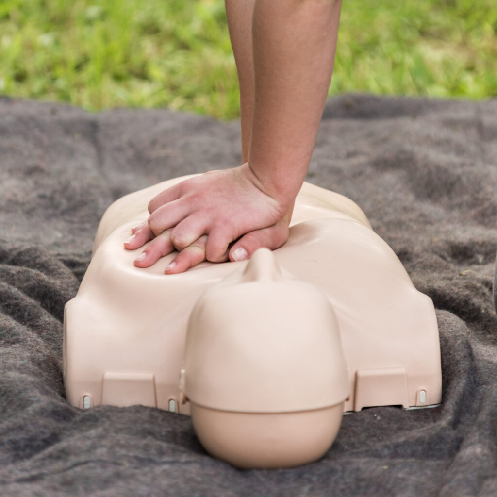 CPR training outdoors. Reanimation procedure on CPR doll