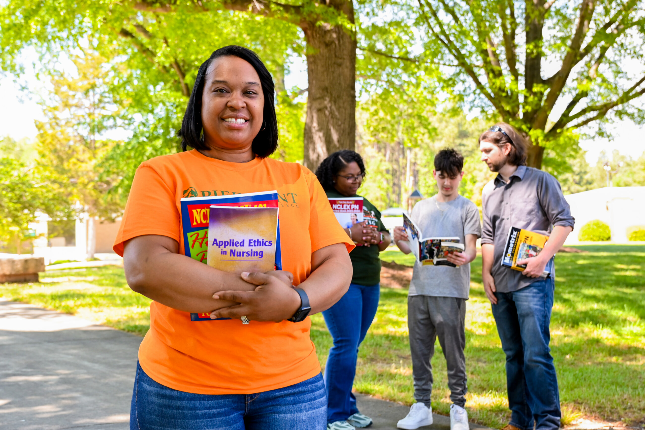 Young PCC student smiling with other students in the background.